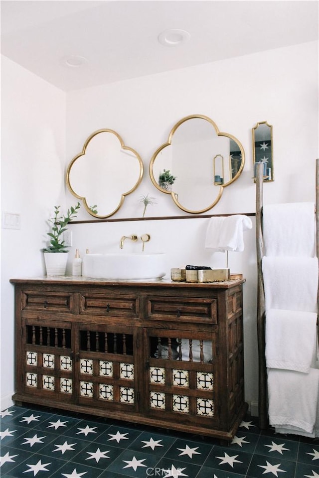 bar featuring sink and dark tile patterned flooring