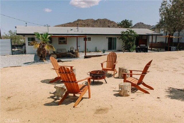 rear view of house featuring a fire pit and a mountain view