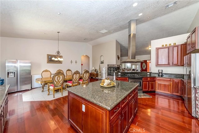 kitchen featuring dark brown cabinets, appliances with stainless steel finishes, ventilation hood, and pendant lighting