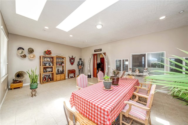 dining area featuring light tile floors and a skylight