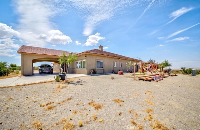 rear view of property featuring stucco siding