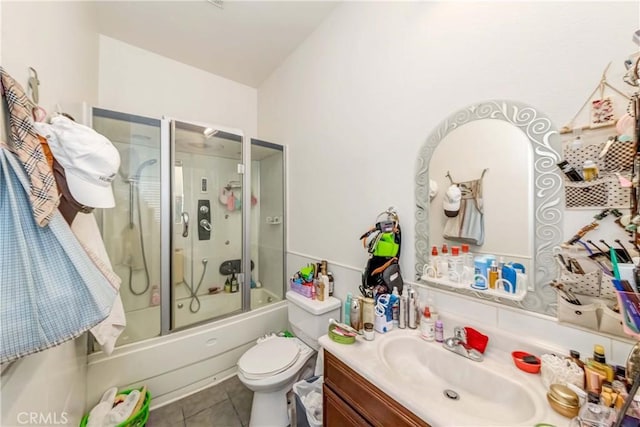 bathroom with tile patterned flooring, shower / bath combination with glass door, vanity, and toilet