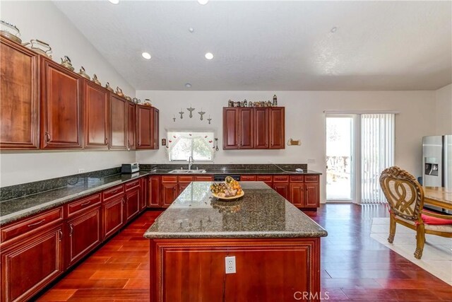 kitchen with plenty of natural light, stainless steel refrigerator with ice dispenser, sink, and a center island