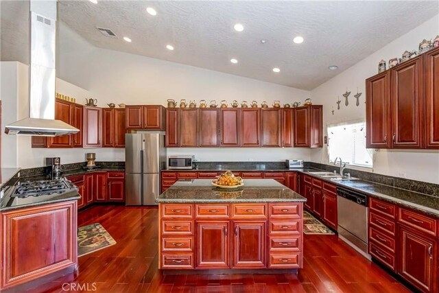 kitchen with dark wood-type flooring, appliances with stainless steel finishes, dark stone countertops, a center island, and island range hood