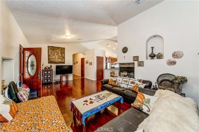 living room with a fireplace, high vaulted ceiling, a textured ceiling, and dark hardwood / wood-style flooring