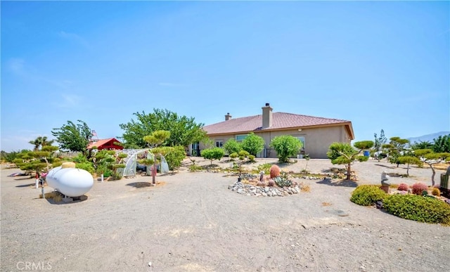 exterior space with a chimney and stucco siding