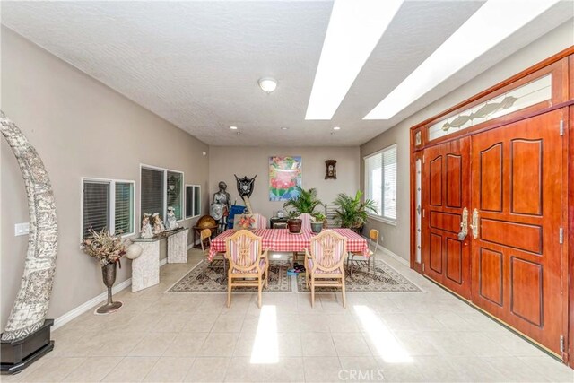 tiled dining room featuring a textured ceiling