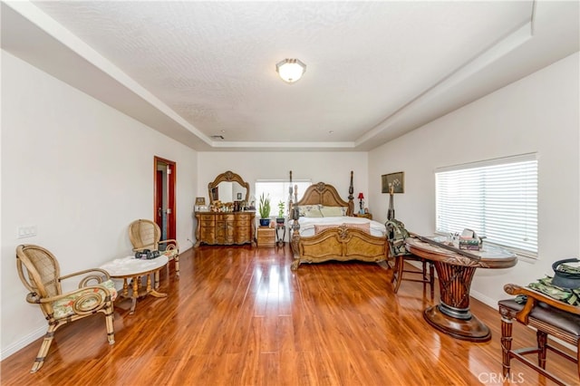 bedroom featuring a tray ceiling and hardwood / wood-style flooring