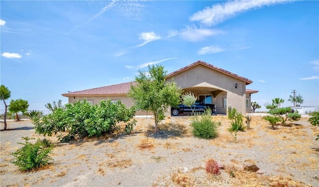 view of front of home with a tiled roof and stucco siding