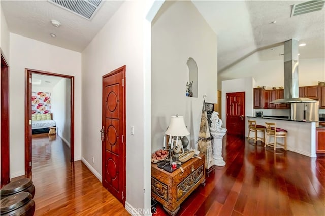 hallway featuring high vaulted ceiling and dark hardwood / wood-style floors