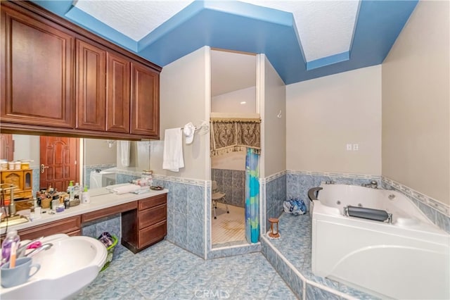 bathroom featuring a textured ceiling, tile flooring, a washtub, and vanity