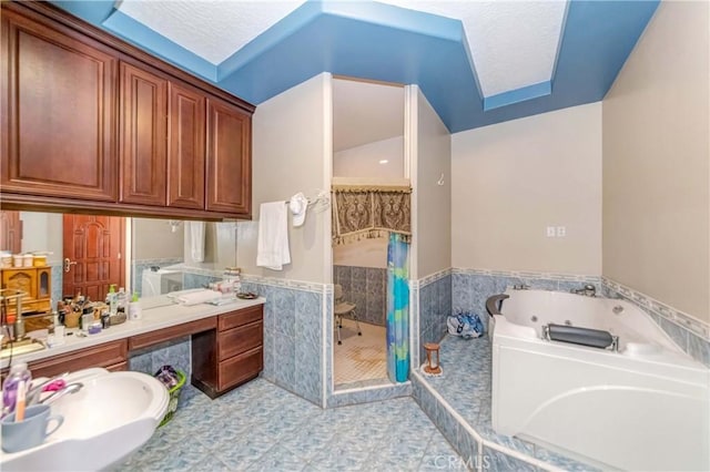 bathroom featuring a wainscoted wall, tile walls, a stall shower, vanity, and a tub with jets