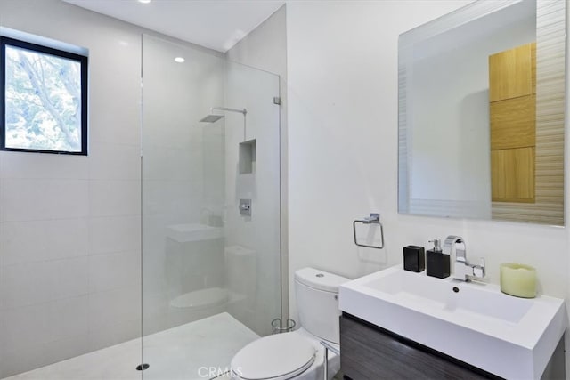 bathroom with vanity, a shower with shower door, and toilet