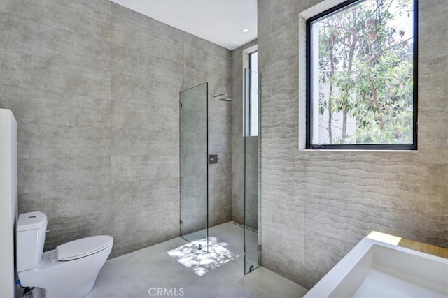 bathroom featuring a shower with shower door and toilet