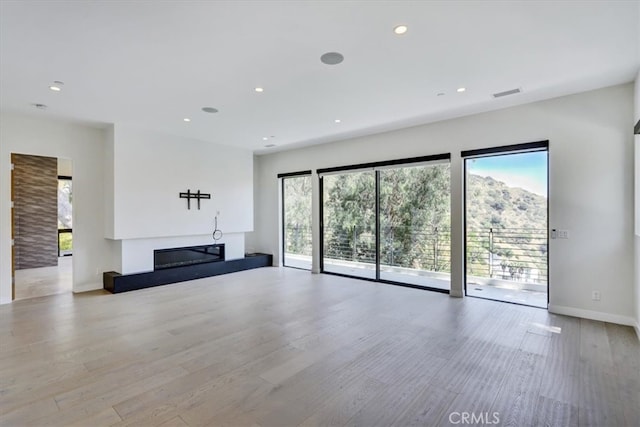 unfurnished living room with light hardwood / wood-style floors and a wealth of natural light