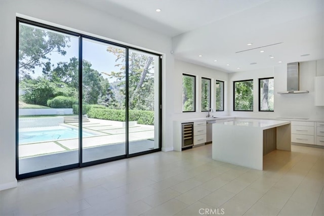 kitchen featuring beverage cooler, wall chimney exhaust hood, black electric stovetop, white cabinetry, and dishwasher