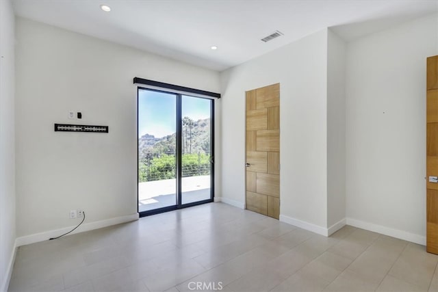 empty room featuring light tile floors and plenty of natural light