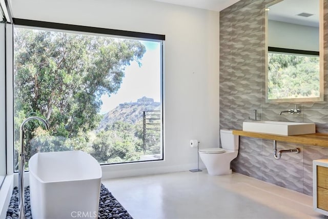 bathroom featuring vanity, a wealth of natural light, and toilet