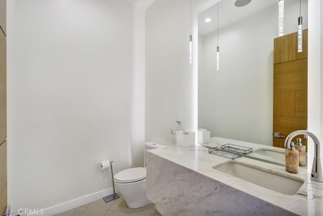 bathroom with tile flooring, large vanity, and toilet