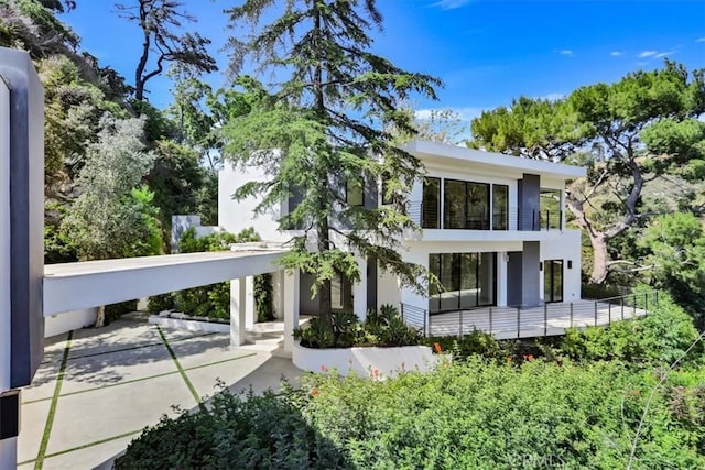 rear view of property featuring a balcony and stucco siding