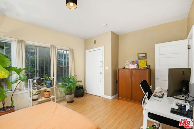 home office with light hardwood / wood-style floors