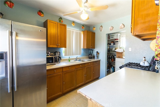 kitchen with ceiling fan, appliances with stainless steel finishes, light tile floors, and sink