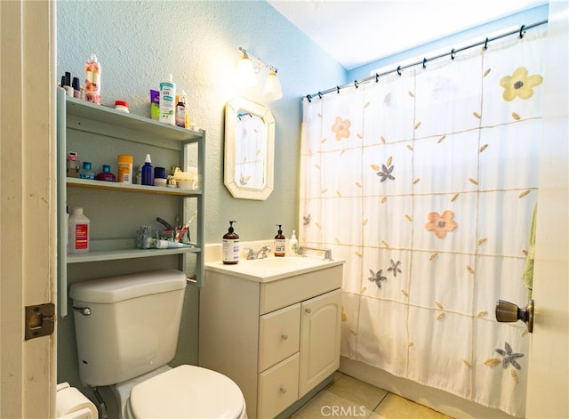 bathroom featuring tile floors, toilet, and vanity with extensive cabinet space