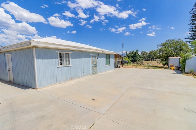 view of home's exterior featuring a storage unit and a patio area