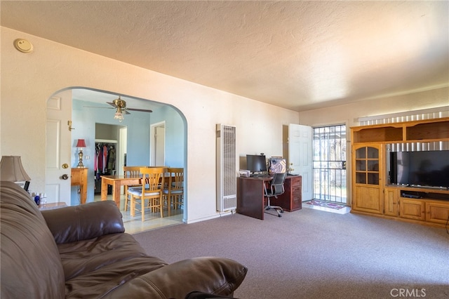 carpeted living room with a textured ceiling and ceiling fan