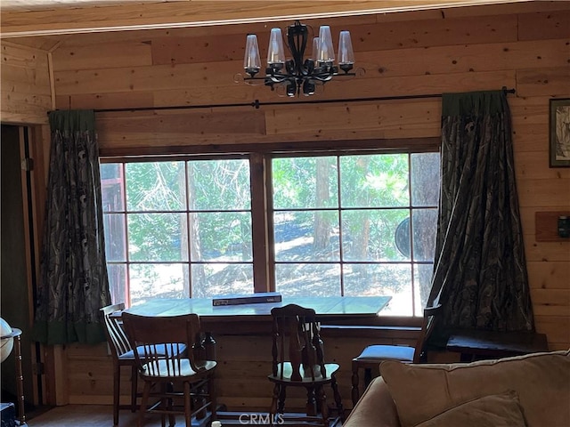 dining room featuring wood walls and a chandelier