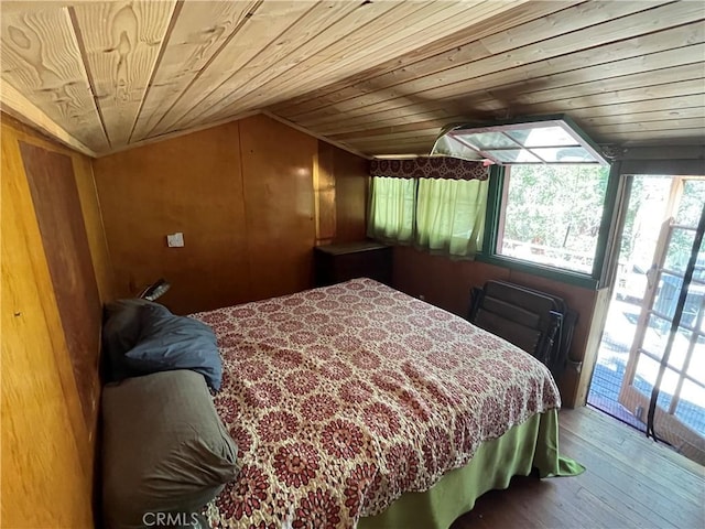 bedroom with wood walls, hardwood / wood-style floors, wood ceiling, and lofted ceiling