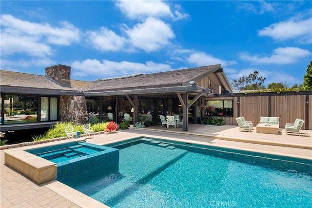 view of swimming pool featuring an in ground hot tub and a patio