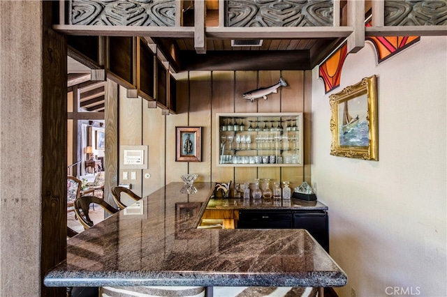 bar with beam ceiling and dark stone countertops