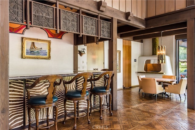 bar with a chandelier and dark parquet flooring