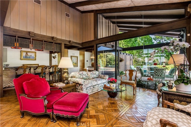 living room featuring wooden walls, light parquet floors, high vaulted ceiling, and beam ceiling