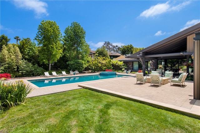 view of pool featuring a lawn and a patio