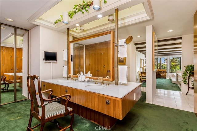 interior space with a raised ceiling, oversized vanity, crown molding, and tile flooring