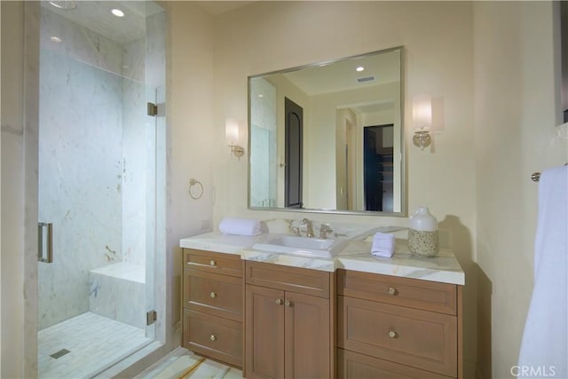 bathroom with a shower with shower door and vanity