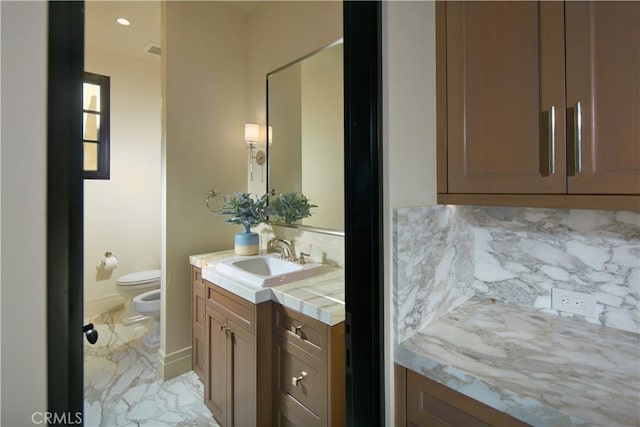 bathroom with a bidet, backsplash, vanity, and toilet