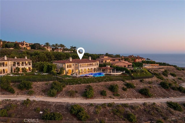 aerial view at dusk featuring a water view