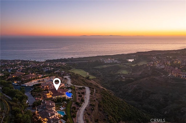 aerial view at dusk featuring a water view