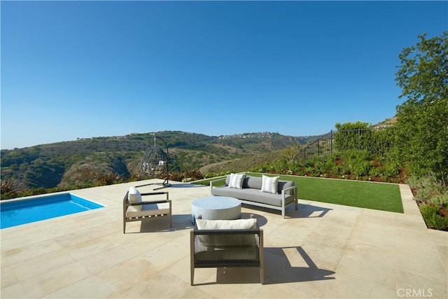 view of swimming pool featuring a patio area, a mountain view, and outdoor lounge area