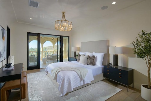 bedroom featuring access to exterior, a notable chandelier, and light hardwood / wood-style flooring