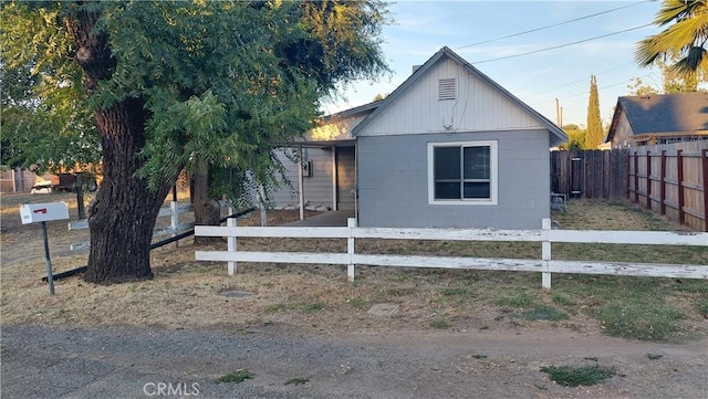 view of front facade featuring concrete block siding and a fenced front yard