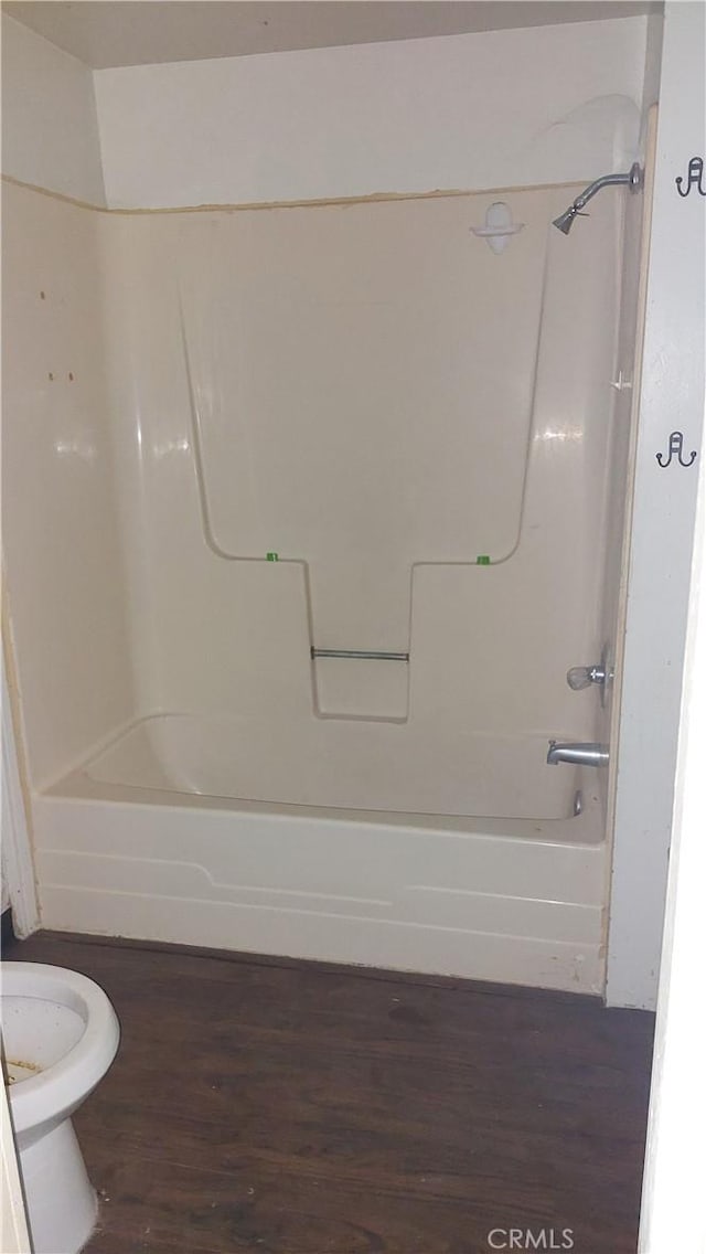 bathroom featuring tub / shower combination, wood finished floors, and toilet