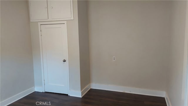 unfurnished room with dark hardwood / wood-style flooring