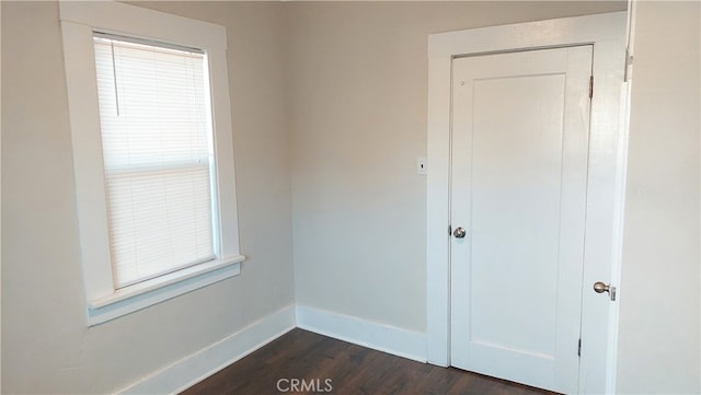 unfurnished room featuring plenty of natural light and dark hardwood / wood-style flooring