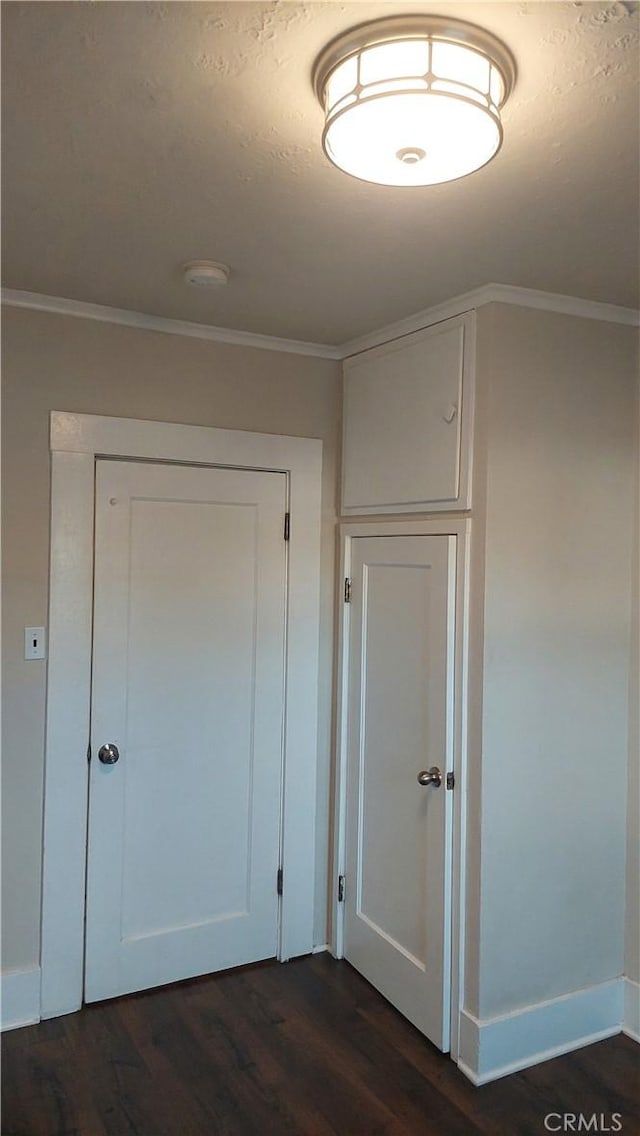 hallway featuring ornamental molding, baseboards, and dark wood finished floors
