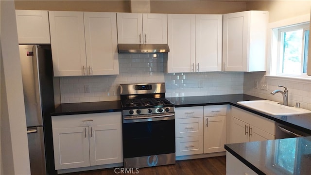 kitchen featuring white cabinets, dark hardwood / wood-style floors, stainless steel appliances, backsplash, and sink