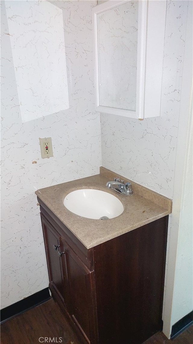 bathroom featuring vanity with extensive cabinet space and hardwood / wood-style flooring